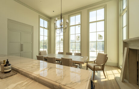 Trim and molding accent floor to ceiling windows in this showstopping dining room.