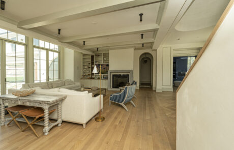 White ceiling beams and wall paneling in a stunning home remodel project.