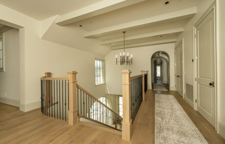 Beautiful ceiling beams and curving wood and metal staircase in a home remodel project.